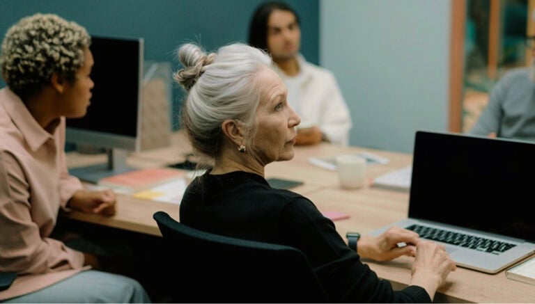 Person arbeitet am Laptop in einer Besprechung